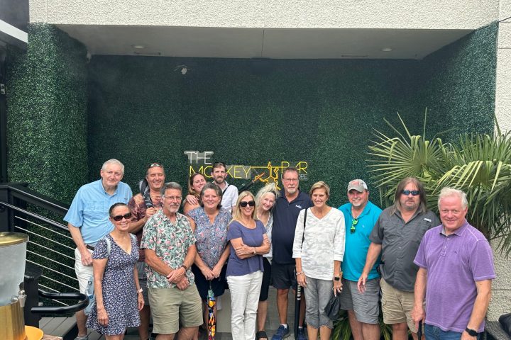 John Desko et al. standing in front of a crowd posing for the camera